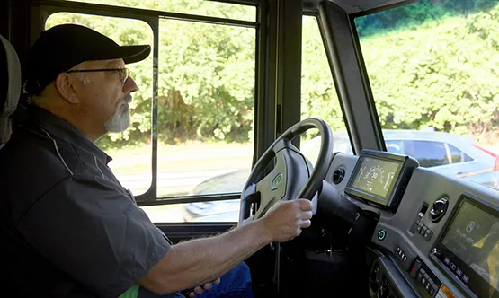 View of driver inside the class 4 cab steering the vehicle